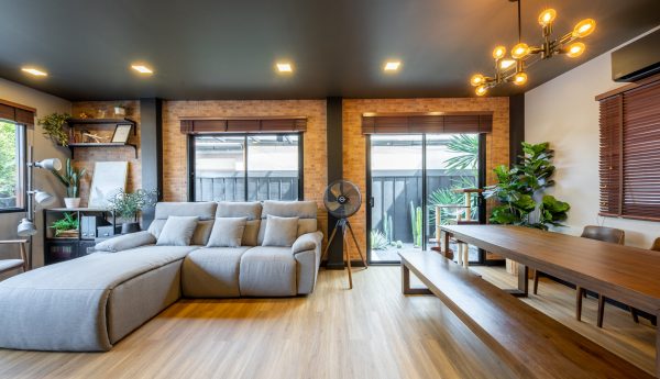 Living room with grey sofa and almond brown spc flooring Living room with grey sofa and almond brown spc flooring